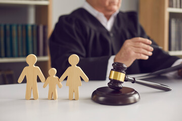 judge with gavel and wooden figurines of family