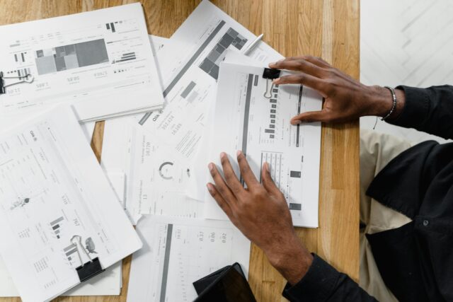 person's hands with financial information documents